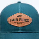 Close up of genuine leather Fair Flies patch stitched on to teal LoPro Trucker cap hat front.  Beautiful.